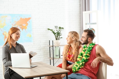 Photo of Beautiful young couple visiting travel agency office