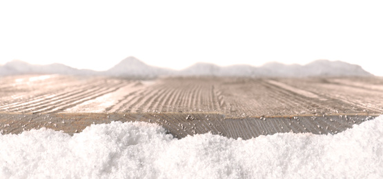 Heap of snow near wooden surface isolated on white