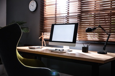 Stylish room interior with modern computer and comfortable office chair