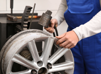 Photo of Mechanic working with car disk lathe machine at tire service, closeup