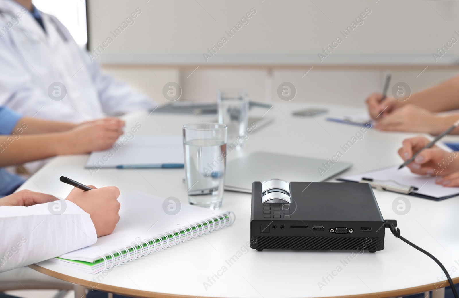 Photo of Team of doctors using video projector during conference indoors