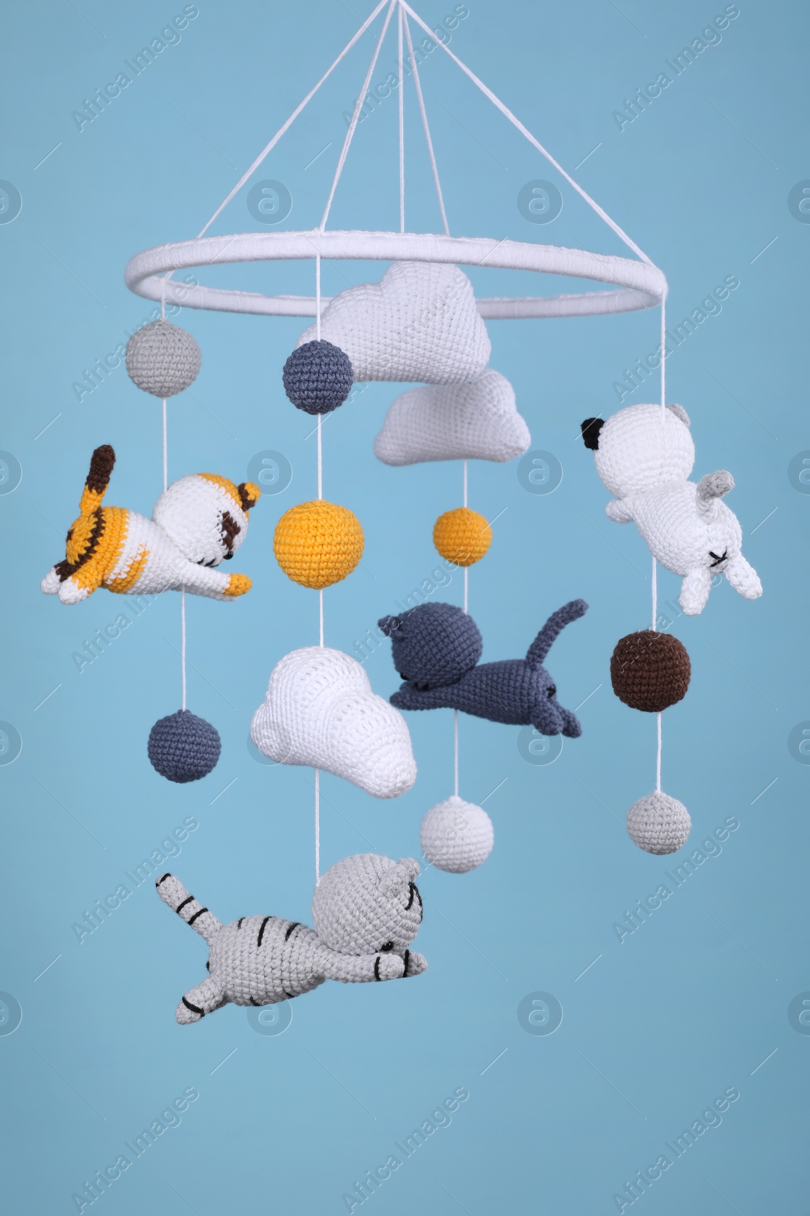 Photo of Cute baby crib mobile on light blue background