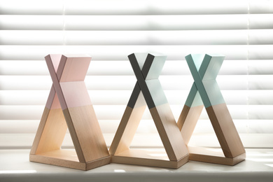 Photo of Wigwam shaped shelves on windowsill indoors. Interior elements