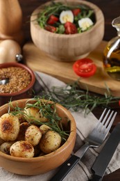 Photo of Delicious grilled potatoes with tarragon, mustard and salad on table