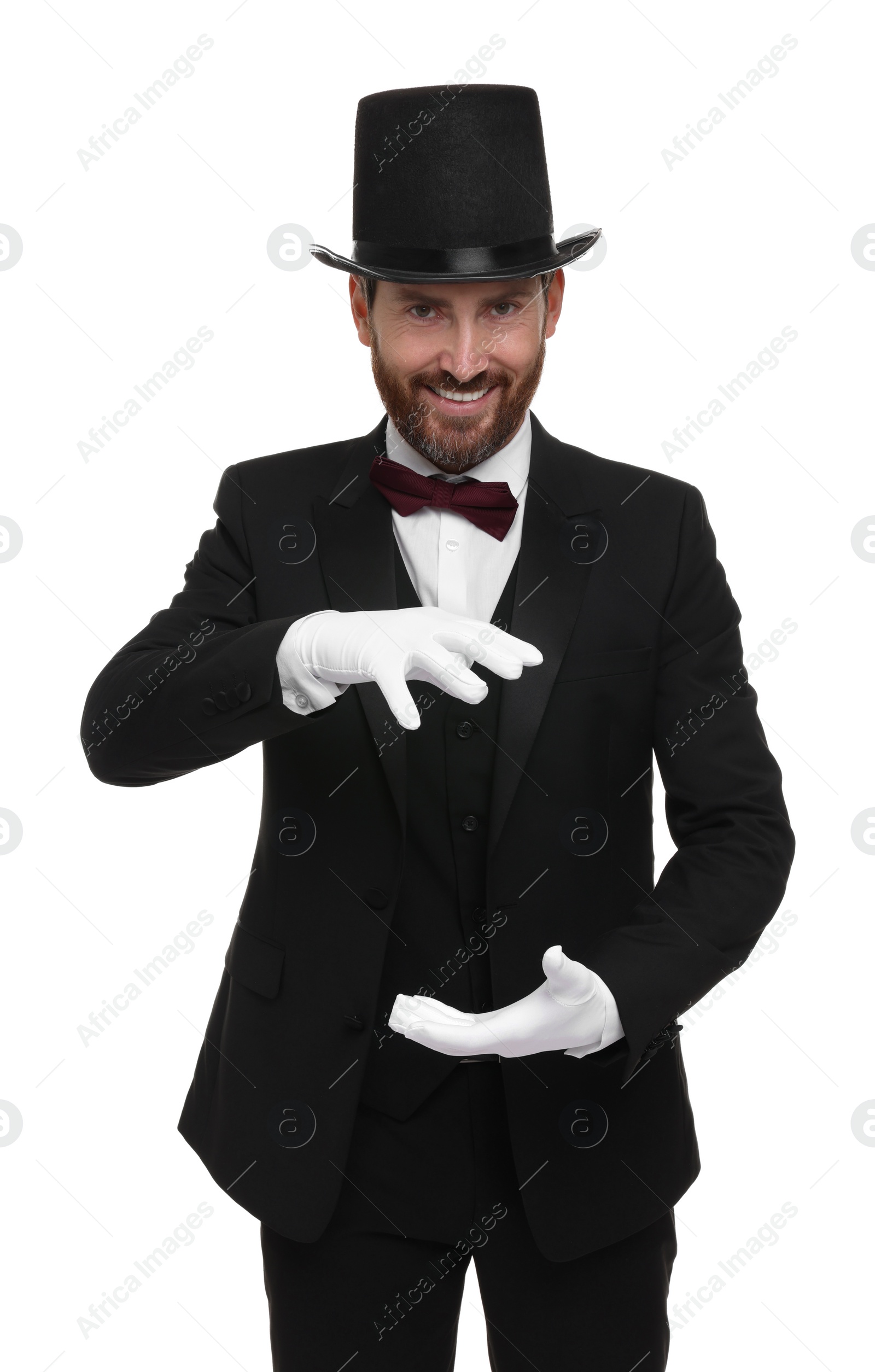 Photo of Happy magician in top hat holding something on white background