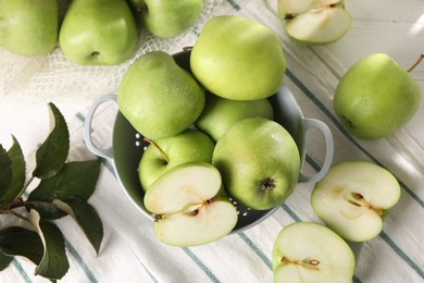 Photo of Fresh green apples with water drops and leaves on white wooden table, flat lay