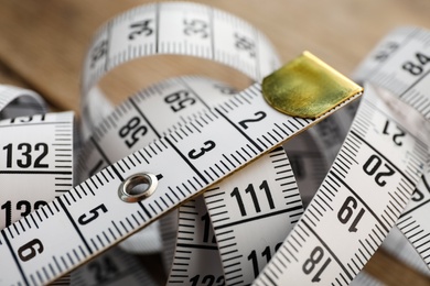 New white measuring tape on table, closeup