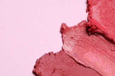 Photo of Smears of beautiful lipsticks on pink background, closeup