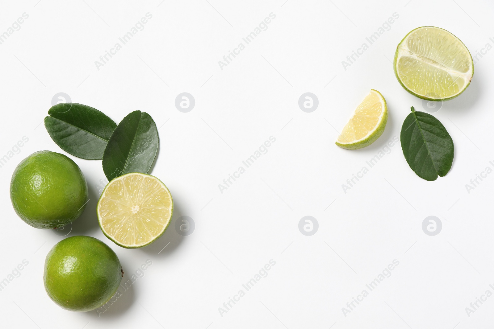 Photo of Fresh ripe limes and leaves on white background, flat lay. Space for text