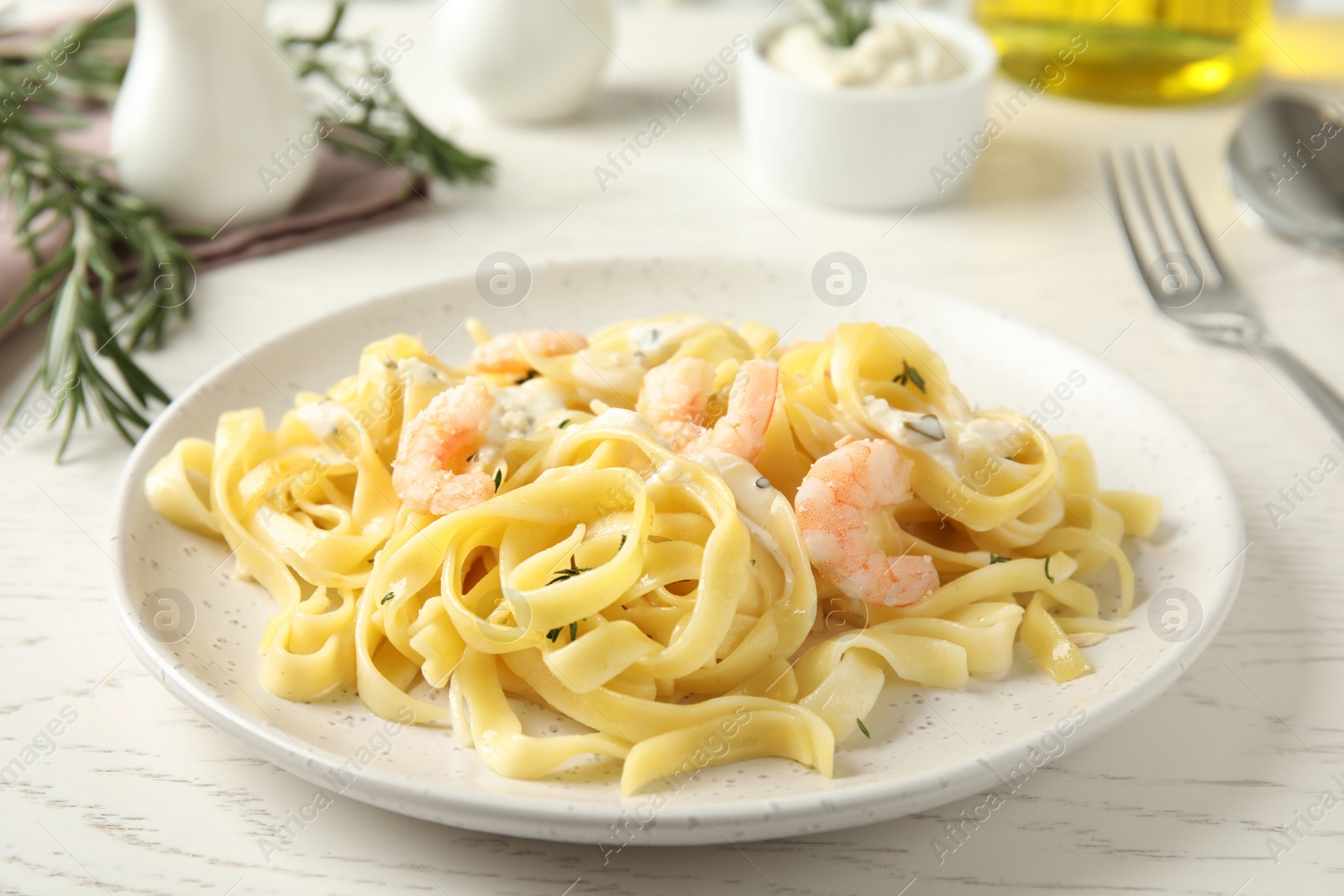 Photo of Delicious pasta with shrimps on white wooden table