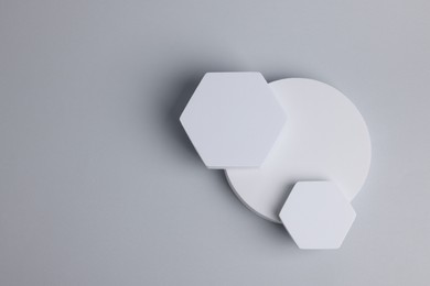 Photo of Scene for product presentation with space for text. Podiums of different geometric shapes on light grey background, top view