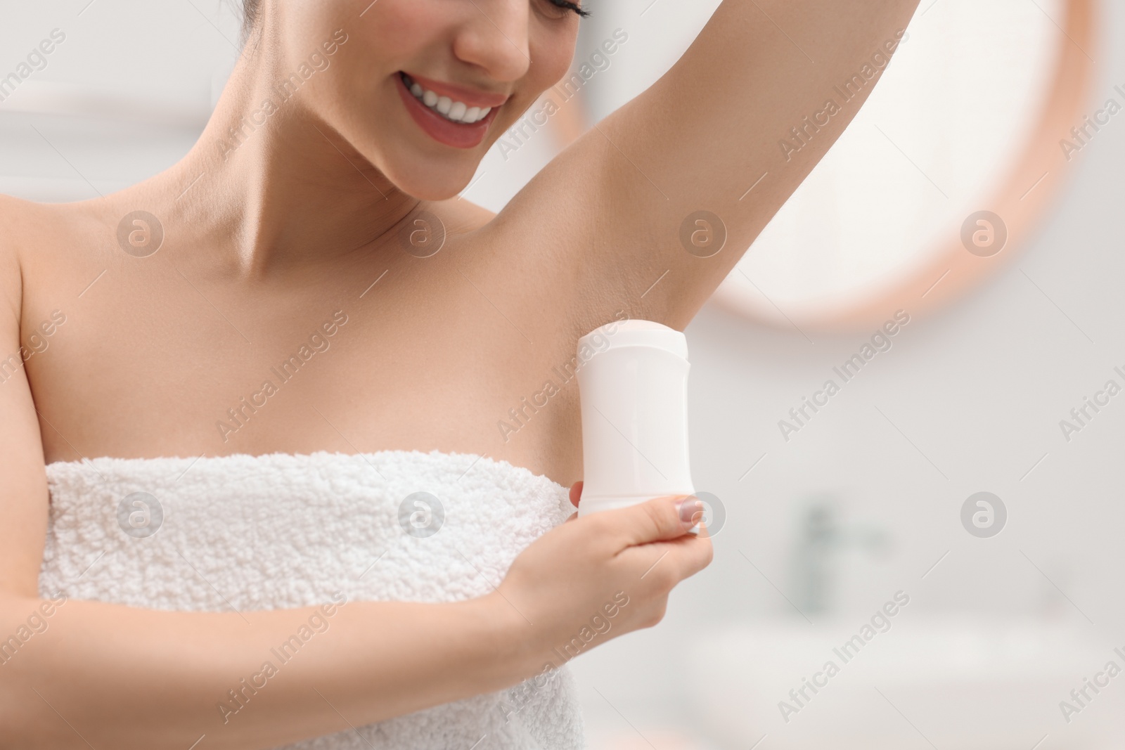 Photo of Woman applying deodorant in bathroom, closeup view