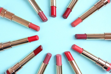 Photo of Flat lay composition with different stylish lipsticks on color background, space for text
