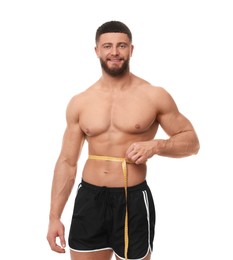 Photo of Happy athletic man measuring waist with tape on white background. Weight loss concept