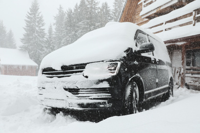 Photo of Modern car covered with snow outdoors on winter day