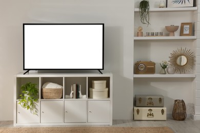 Image of Modern TV set on stand in room