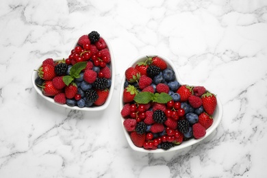 Photo of Mix of ripe berries on white marble table, flat lay