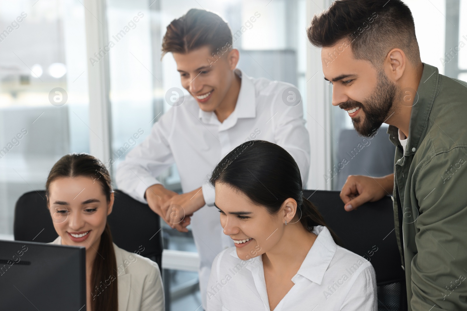 Photo of Colleagues working together in open plan office