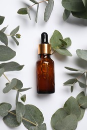 Aromatherapy product. Bottle of essential oil and eucalyptus leaves on white background, flat lay