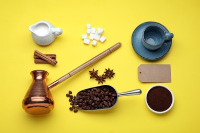 Photo of Flat lay composition with turkish coffee pot and roasted beans on yellow background