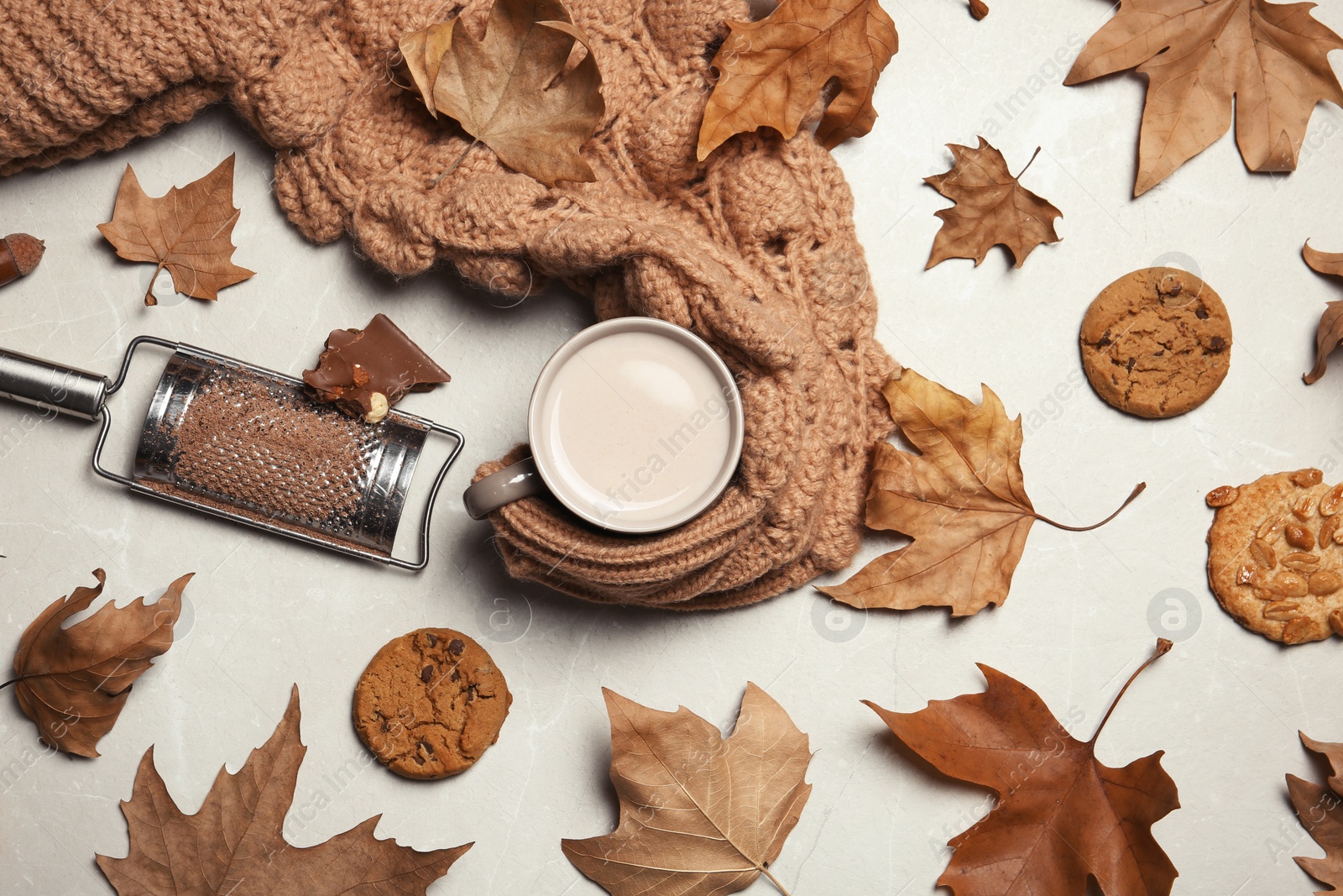 Photo of Flat lay composition with hot cozy drink and autumn leaves on light background