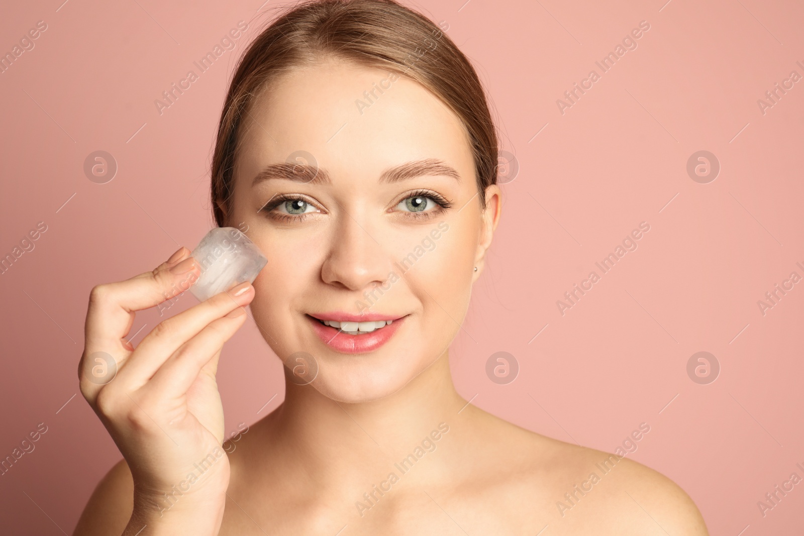 Photo of Young woman with ice cube on color background. Skin care