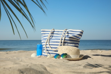 Stylish beach accessories on sandy sea shore