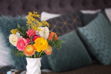 Photo of Vase with beautiful ranunculus flowers on blurred background