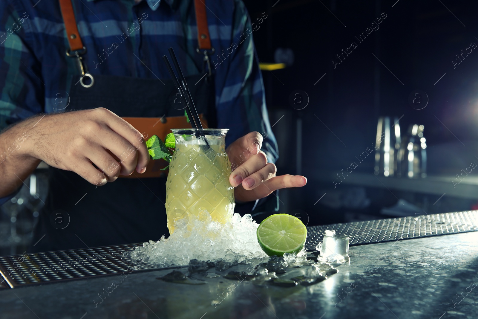 Photo of Barman making tropical cocktail at counter in pub, closeup. Space for text