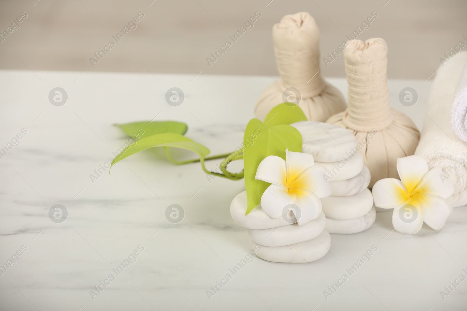 Photo of Composition with different spa products and plumeria flowers on white marble table, space for text