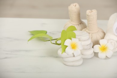 Photo of Composition with different spa products and plumeria flowers on white marble table, space for text