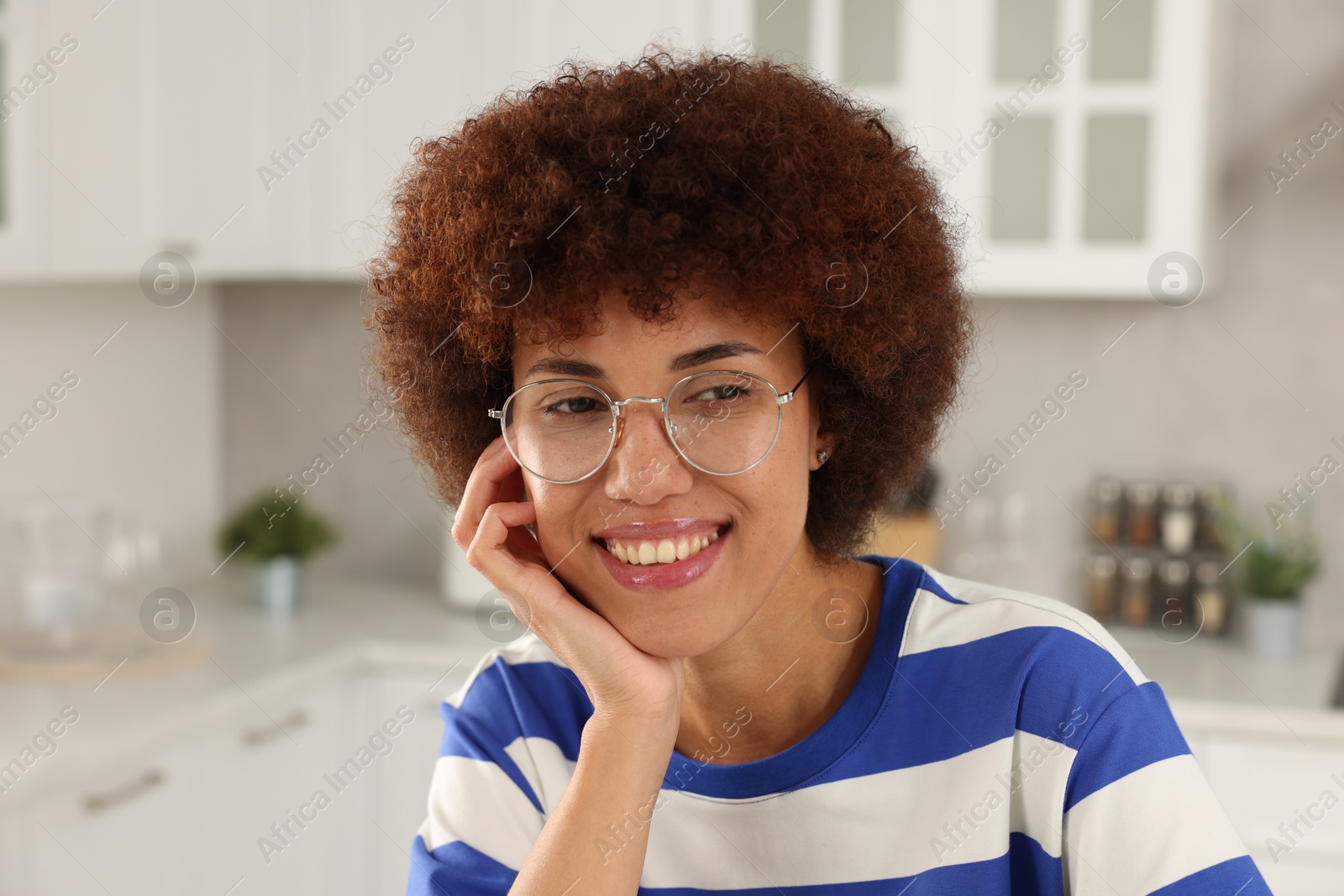 Photo of Portrait of happy young woman with eyeglasses in kitchen