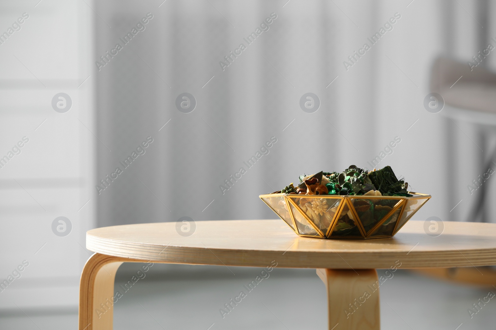 Photo of Decorative bowl with aromatic potpourri on wooden table in room, space for text