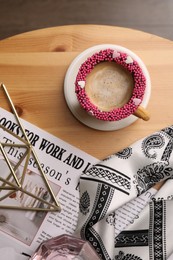 Photo of Flat lay composition with delicious edible biscuit cup of coffee decorated with sprinkles on wooden table