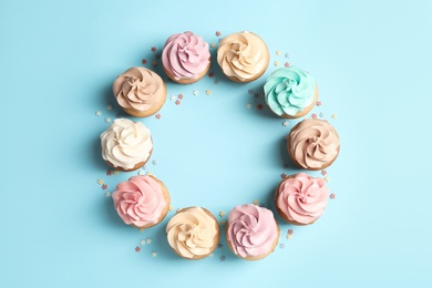 Photo of Flat lay composition with delicious birthday cupcakes and space for text on color background