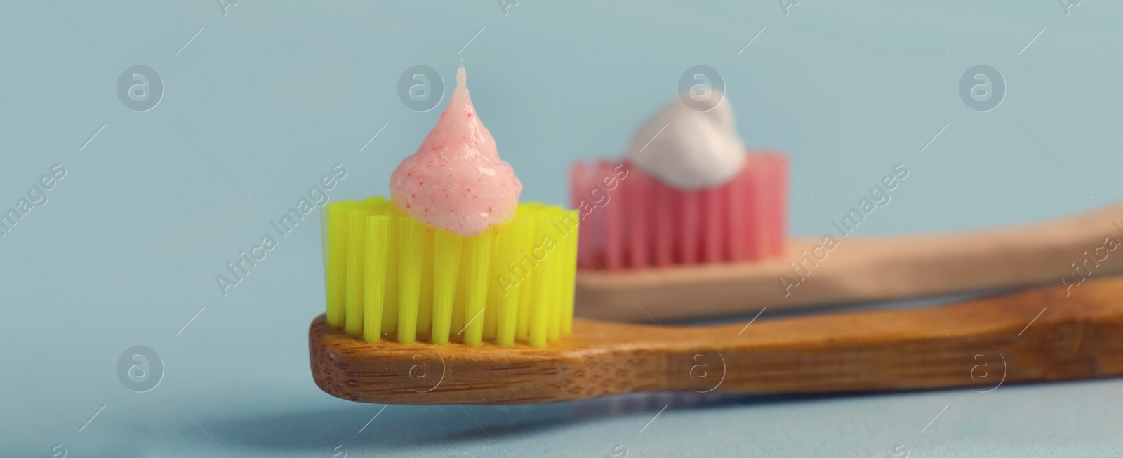 Image of Brushes with toothpastes on light blue background, banner design