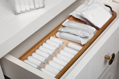 Photo of Storage of different feminine products in white drawer, closeup