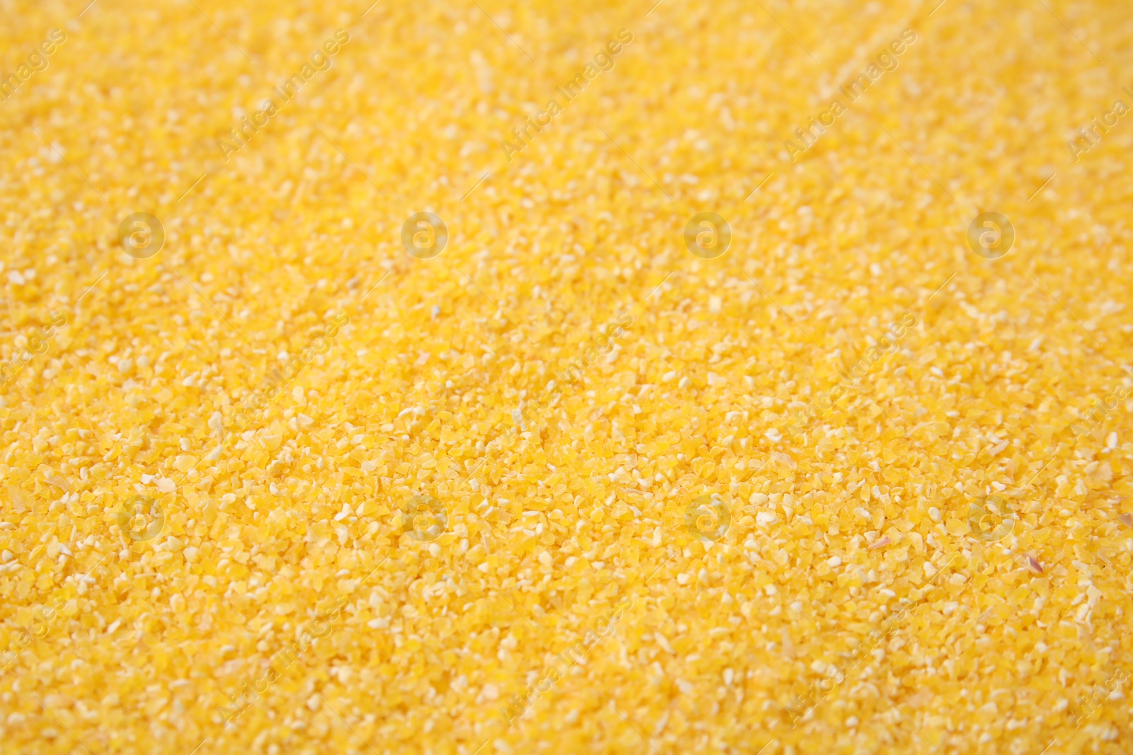 Photo of Raw corn grits as background, closeup view