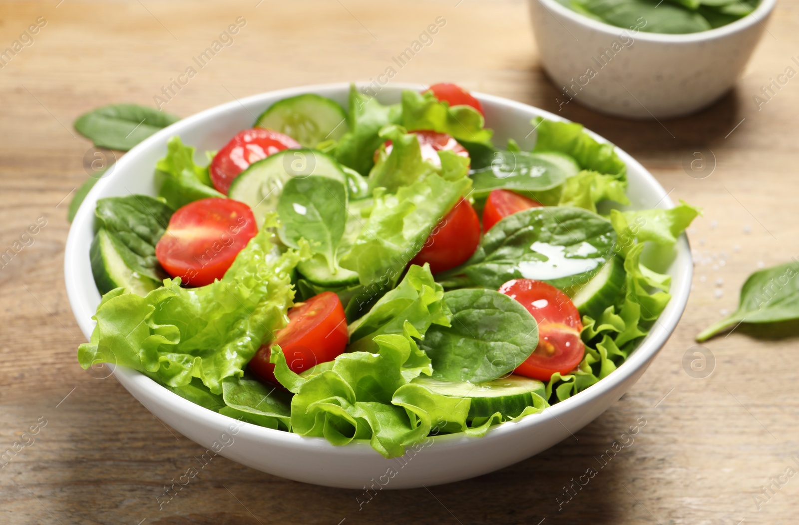 Photo of Delicious vegetable salad on wooden table, closeup