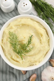 Photo of Bowl of tasty mashed potato with garlic and dill on table, flat lay