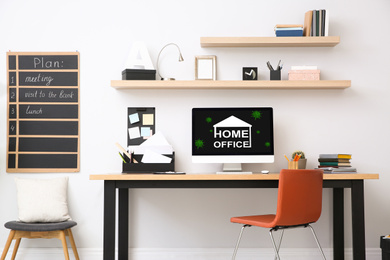 Image of Modern computer with text HOME OFFICE on wooden table indoors