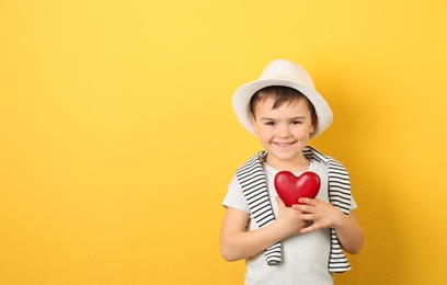 Photo of Portrait of boy with decorative heart on color background. Space for text