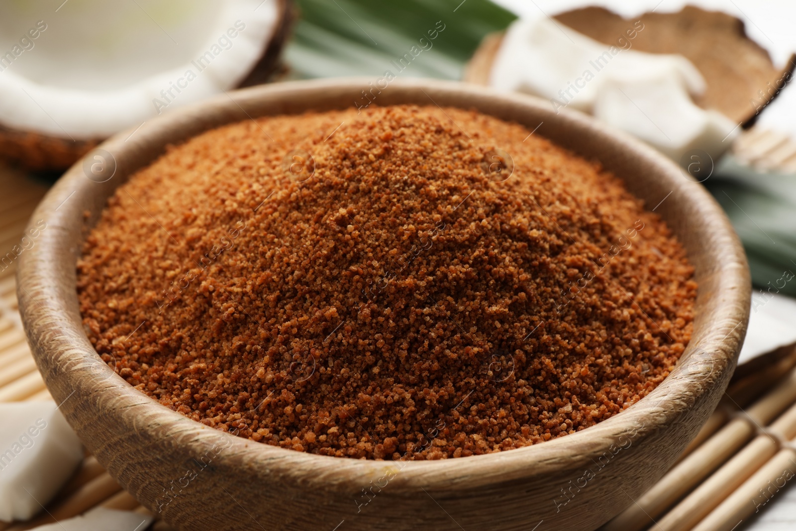 Photo of Natural coconut sugar in wooden bowl, closeup