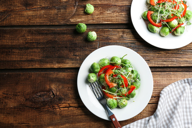 Photo of Tasty salad with Brussels sprouts served on wooden table, flat lay. Space for text