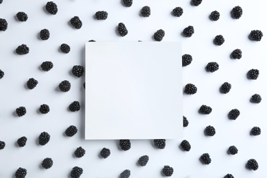 Photo of Fresh blackberries and blank card on white background, top view. Space for text