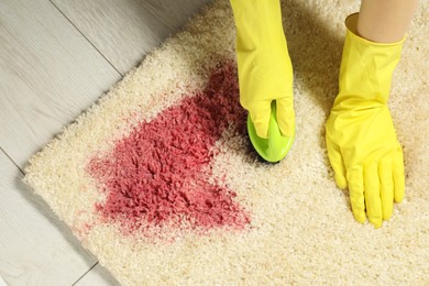 Photo of Woman removing stain from beige carpet, top view