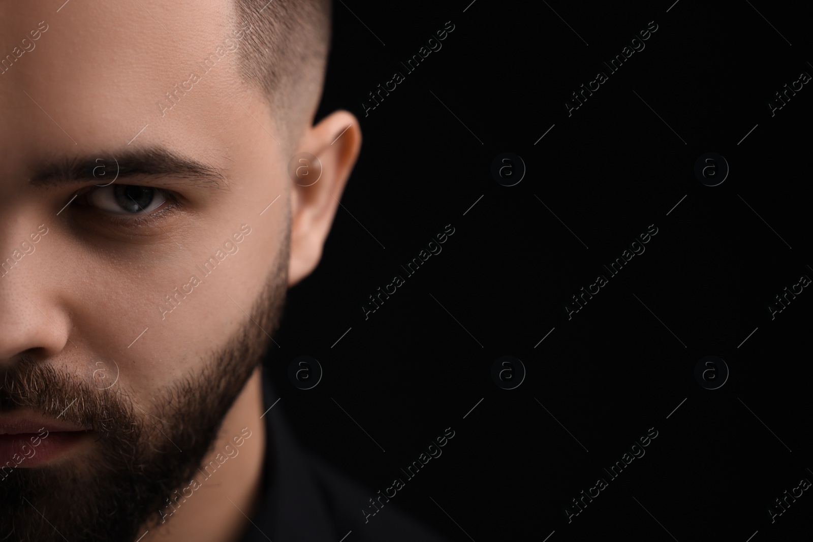 Photo of Evil eye. Man with scary eyes on black background, space for text