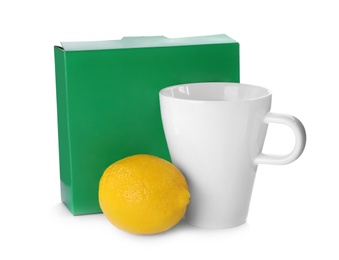 Photo of Cup of hot tea, lemon and box with medicine on white background