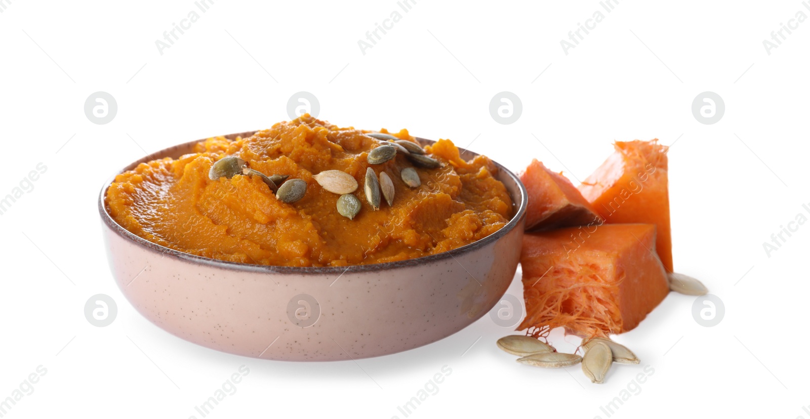 Photo of Delicious vegetable puree with pumpkin pieces and seeds on white background. Healthy food