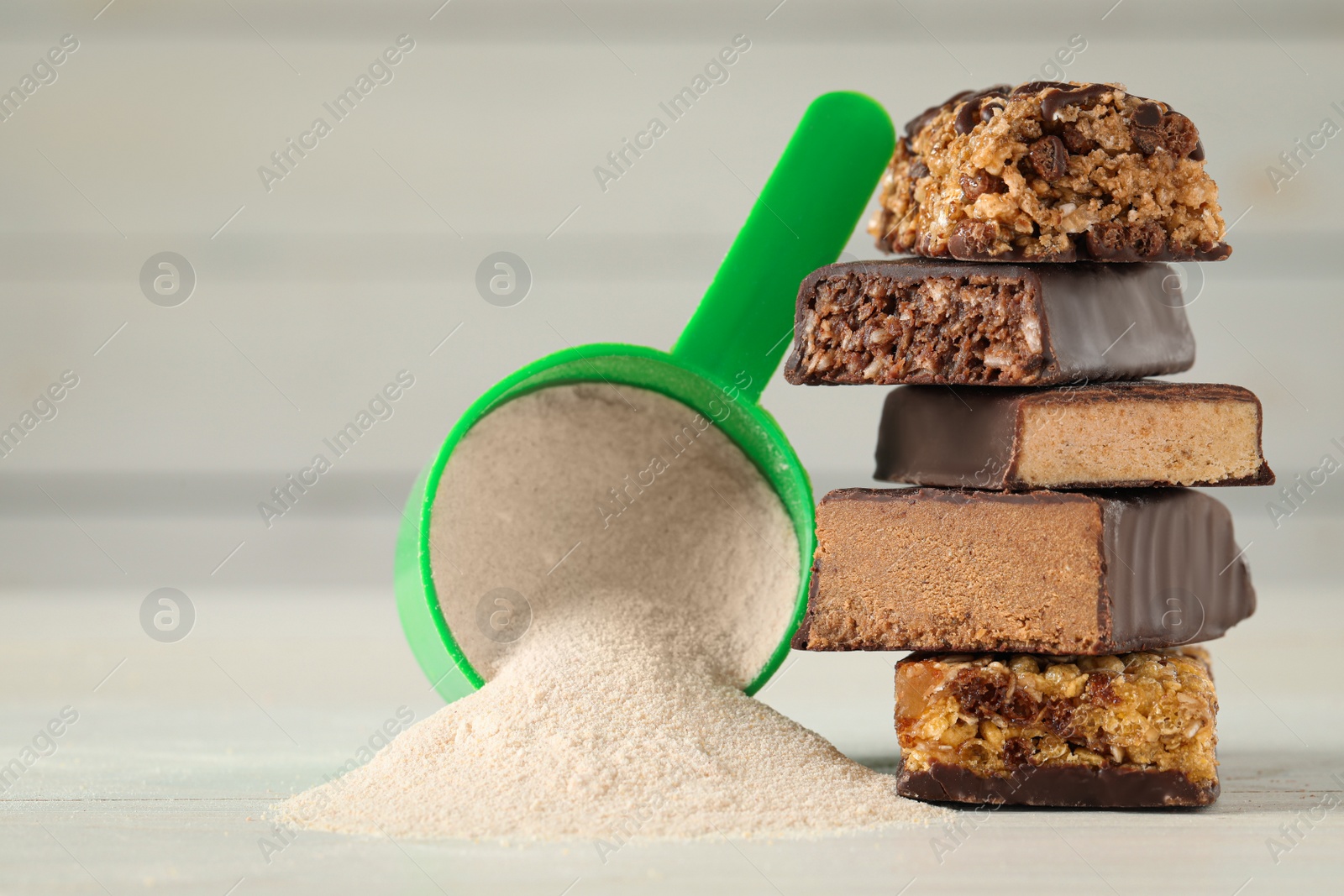 Photo of Different tasty energy bars and protein powder on white table, closeup